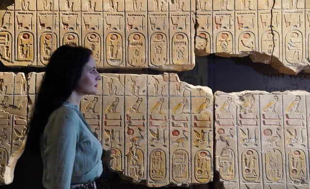A member of staff observes the Abydos King List on display during the Hieroglyphs: unlocking ancient Egypt exhibition at the British Museum in London on Tuesday, October 11, 2022. (Photo by Jonathan Brady/PA Images via Getty Images)