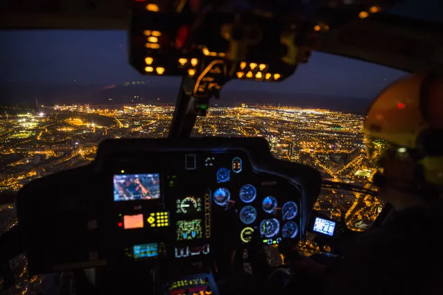 In this Tuesday, September 19, 2017 photo, an officer pilots a Catalan Mossos d'Esquadra helicopter flies over the city of Barcelona, Spain during a patrol. Spain's Catalonia region has its own police force, known locally as the Mossos d'Esquadra, and it has grown from its 18th-century roots into a modern European security agency with about 17,000 members. (Photo by Emilio Morenatti/AP Photo)