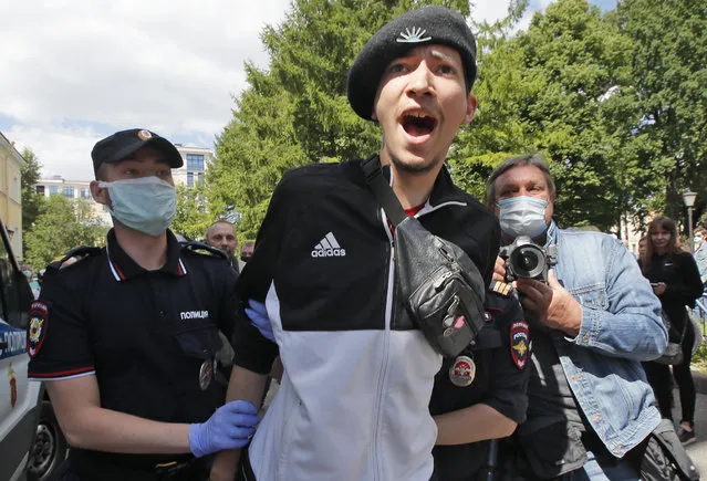 Police detain a man protesting against the court verdict for Yuliy Boyarshinov, and Viktor Filinkov, members of a left-wing group Set (Network) at the Western regional military court in St.Petersburg, Russia, Monday, June 22, 2020. (Photo by Dmitri Lovetsky/AP Photo)