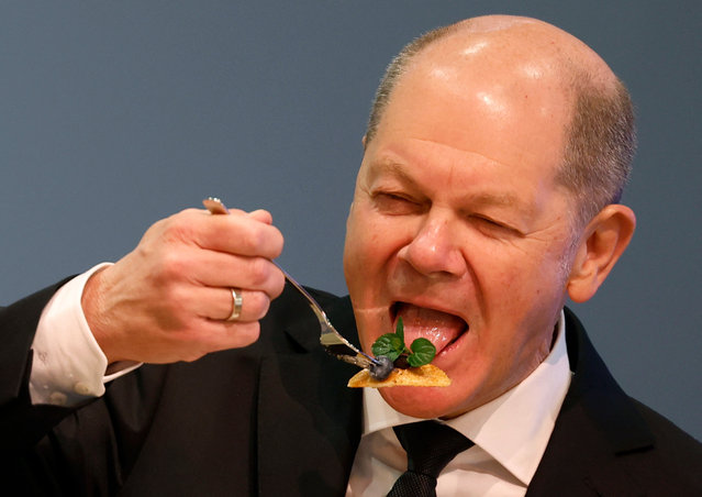 German Chancellor Olaf Scholz tastes a self-made pancake as he tours the International Agriculture Fair “Green Week” (Gruene Woche) in Berlin on January 22, 2024. According to the organisers, around 1,400 exhibitors from 60 countries will present their products and services relating to food, agriculture and horticulture. The fair will be running from January 19 to 28, 2024. (Photo by Odd Andersen/AFP Photo)