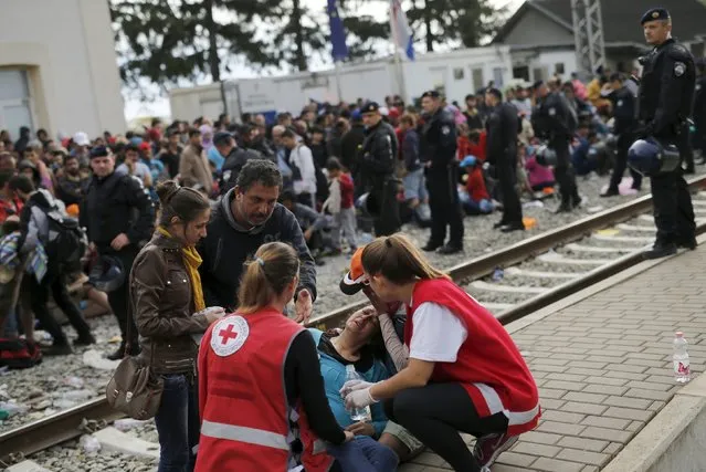 Red Cross workers attend to a migrant at the train station in Tovarnik, Croatia, September 20, 2015. (Photo by Antonio Bronic/Reuters)