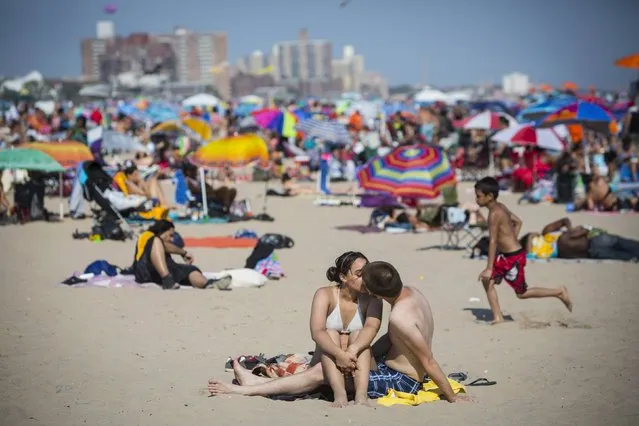A man and woman kiss on the beach at Coney Island Beach in Brooklyn, New York August 15, 2015. (Photo by Andrew Kelly/Reuters)