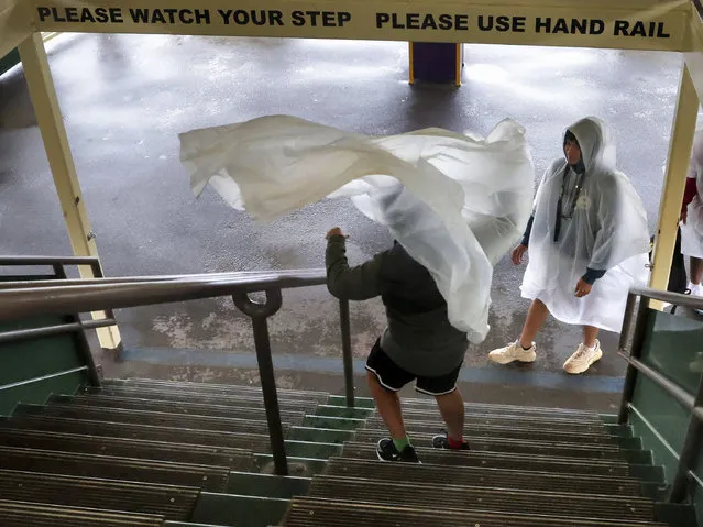 A gust of window blows a guest's rain poncho on the ferry boat on the way to the Magic Kingdom at Walt Disney World in Lake Buena Vista, Fla., Wednesday, November 9, 2022, as conditions deteriorate with the approach of Hurricane Nicole. All 4 Disney parks in Central Florida closed early Wednesday because of the impending storm. (Photo by Joe Burbank/Orlando Sentinel via AP Photo)