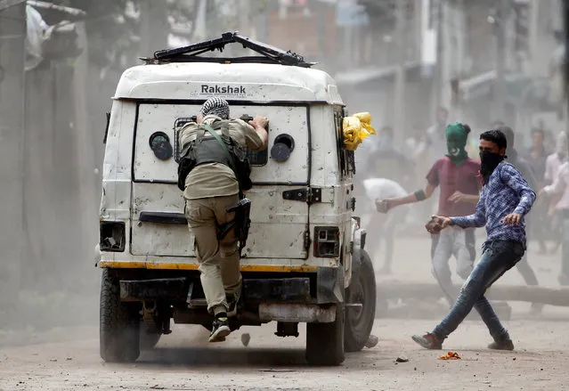 Demonstrators try to hurl stones at an Indian police vehicle during a protest in Srinagar against the recent killings in Kashmir, August 30, 2016. Clashes and curfew continued in parts of Srinagar on Tuesday after anti-India protests and clashes erupted in several neighborhoods, a day after authorities lifted a curfew imposed in most parts of Indian-controlled Kashmir as part of a 52-day security lockdown. (Photo by Danish Ismail/Reuters)