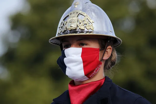 A firefighter wears a face mask with the colors of the French flag, prior to the Bastille Day parade Tuesday, July 14, 2020 on the Champs Elysees avenue in Paris. (Photo by Christophe Ena/AP Photo/Pool)