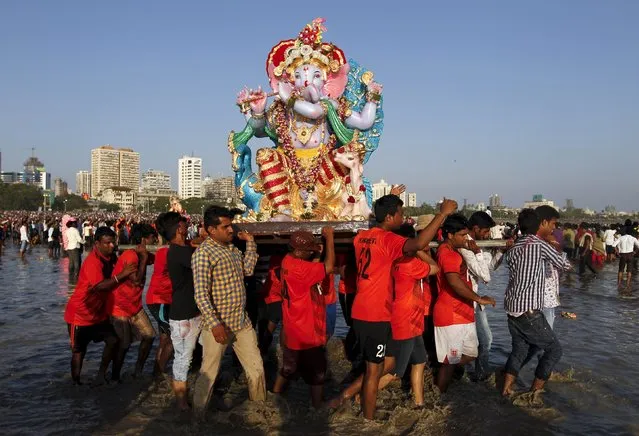 Devotees carry an idol of Hindu elephant god Ganesh, the deity of prosperity, for immersion into the Arabian Sea on the last day of the Ganesh Chaturthi festival in Mumbai, India, September 27, 2015. (Photo by Danish Siddiqui/Reuters)