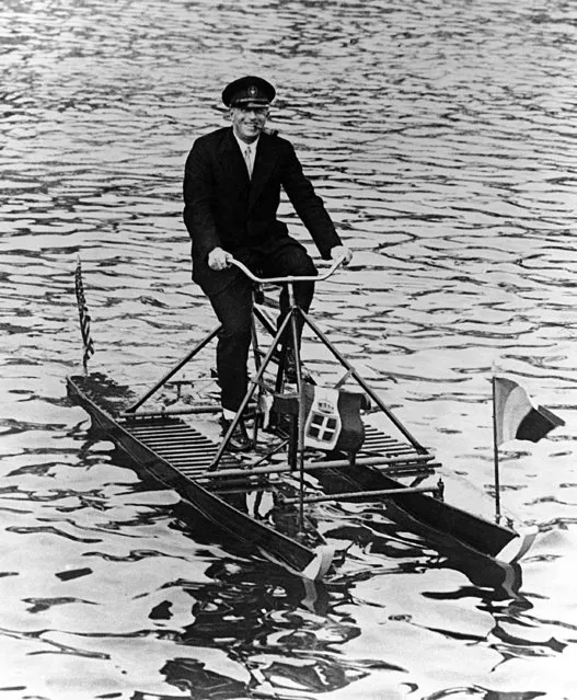 Count Felix Graf von Luckner, German sailor peddling on a new type of watercycle boat at Mackinac Island, Michigan, USA around August 2, 1931. (Photo by AP Photo)