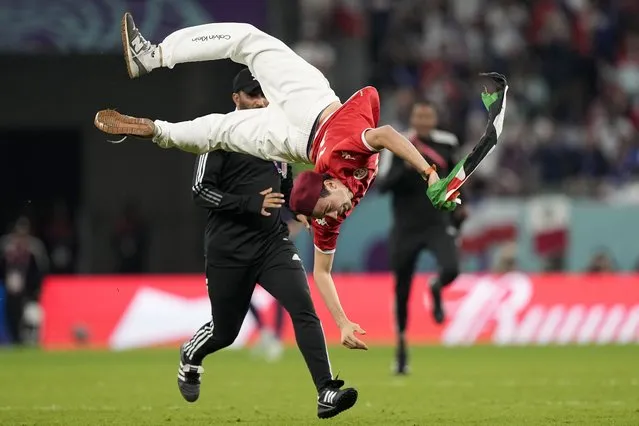 A pitch invader jumps during a World Cup group D soccer match between Tunisia and France at the Education City Stadium in Al Rayyan, Qatar, Wednesday, November 30, 2022. (Photo by Martin Meissner/AP Photo)