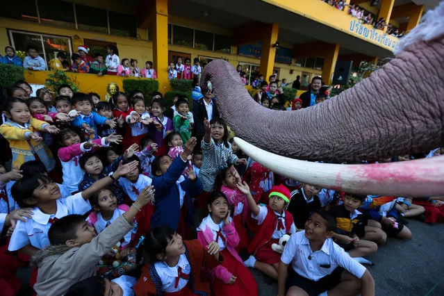 An elephant dressed in a Santa Claus costume distributes a doll to students during Christmas celebrations at Jirasart school in Ayutthaya, Thailand, December 22, 2017. (Photo by Athit Perawongmetha/Reuters)