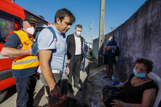 Portuguese Minister of Infrastructure and Housing Pedro Nuno Santos (C) looks on a woman injured in a train crash in Soure, Coimbra, center of Portugal, 31 July 2020. According to reports 72 vehicles with 181 operational and and two planes are being mobilized for the crash site after a train derailed after a collision with maintenance machine leaving at least one person dead and about 50 other passengers injured. (Photo by Paulo Cunha/EPA/EFE)