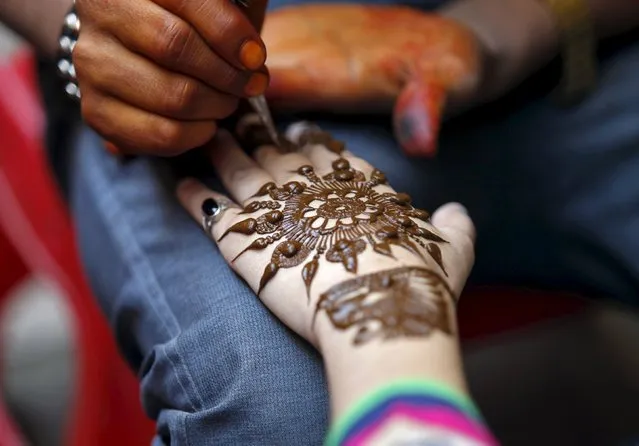 A girl gets her hand decorated with henna paste at a marketplace ahead of the Eid al-Adha festival in Srinagar September 23, 2015. Eid al-Adha in Kashmir falls on Friday. (Photo by Danish Ismail/Reuters)