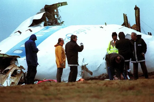 Unidentified crash investigators inspect the nose section of the crashed Pan Am flight 103, a Boeing 747 airliner in a field near Lockerbie, Scotland, December 23, 1988. U.S. and Scottish authorities said Sunday, Dec. 11, 2022 that the Libyan man suspected of making the bomb that destroyed a passenger plane over Lockerbie, Scotland, in 1988 is in U.S. custody. (Photo by Dave Caulkin/AP Photo/File)