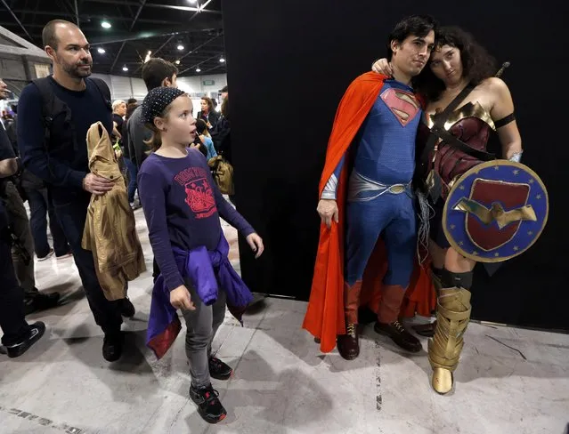 A young girl reacts as participants dressed in superhero costumes pose for a picture during the first edition of the HeroFestival in Marseille, November 9, 2014. (Photo by Jean-Paul Pelissier/Reuters)