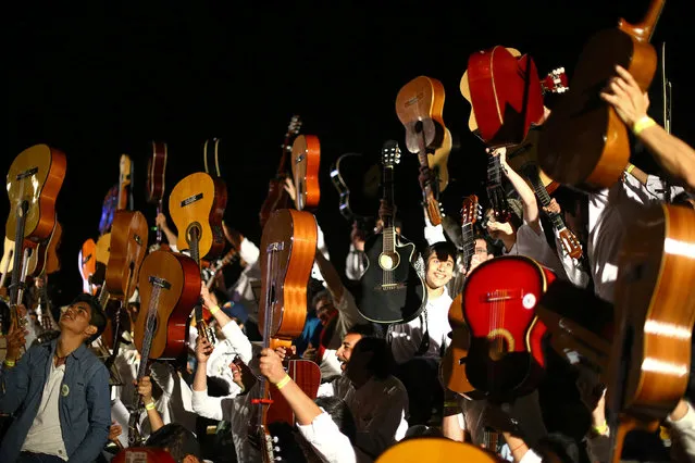 People lift their guitars during “Mil guitarras para Victor Jara” (One thousand guitars to Victor Jara) music concert in Santiago, September 24, 2016. (Photo by Ivan Alvarado/Reuters)