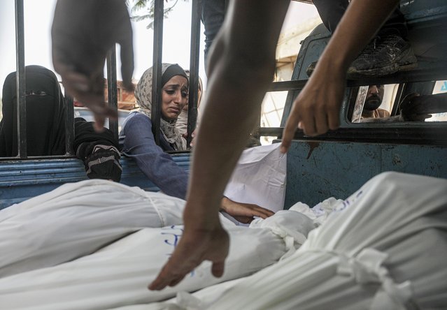 A woman mourns over shrouded bodies of Mushtaha family members at the Al-Shifa in Gaza City, 23 July 2025. According to the Palestinian Ministry of Health in Gaza, more than 36 Palestinians were killed, tem of them from the Mushtaha family, following Israeli airstrikes last night and early today. (Photo by Mohammed Saber/EPA)