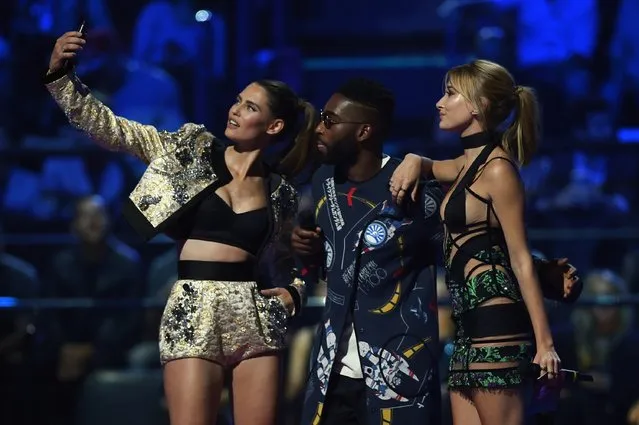 (L-R) Bianca Balti, Tinie Tempah and Hailey Baldwin present the award for Best Video on stage during the MTV EMA's 2015 at the Mediolanum Forum on October 25, 2015 in Milan, Italy. (Photo by Brian Rasic/Getty Images for MTV)