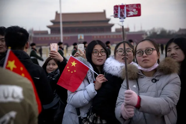 Tourists pose for selfies after the daily flag-raising ceremony at dawn on Tiananmen Square ahead of the opening session of China's National People's Congress (NPC) at the nearby Great Hall of the People in Beijing, Monday, March 5, 2018. (Photo by Mark Schiefelbein/AP Photo)