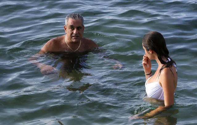 In this October 10, 2015 photo, businessman Ziad Chamoun, a Boston-area restaurant and club owner turned wine importer, swims with guide Hannah Berkeley as he spends the afternoon at a waterfront villa in Havana, Cuba, Saturday. "The next big bubble is going to be nightlife. That's what happened to Cancun," said Chamoun. (Photo by Desmond Boylan/AP Photo)