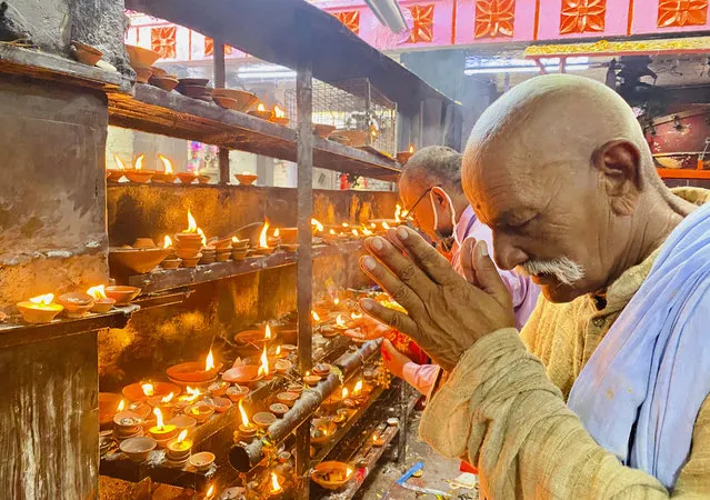An elderly Hindu offers prayers at the Vindhyavasini temple in Mirzapur in the northern Indian state of Uttar Pradesh, Saturday, October 17, 2020. Health officials have warned about the potential for the coronavirus to spread during the upcoming religious festival season, which is marked by huge gatherings in temples and shopping districts. (Photo by Rajesh Kumar Singh/AP Photo)