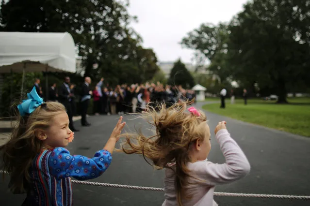 Girls wave as Marine One, carrying U.S. President Barack Obama, leaves the South Lawn of the White House in Washington before his departure to Chicago, October 7, 2016. (Photo by Carlos Barria/Reuters)