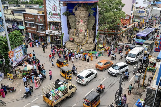 Devotees gather in front of a 42-foot-high idol of the Hindu deity Ganesha on the occasion of the Ganesh Chaturthi festival in Chennai on August 27, 2025. (Photo by R. Satish Babu/AFP Photo)