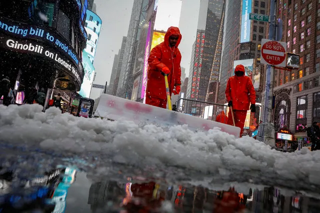 Workers clear snow during a winter nor'easter storm in Times Square in New York City, U.S., March 21, 2018. (Photo by Brendan McDermid/Reuters)