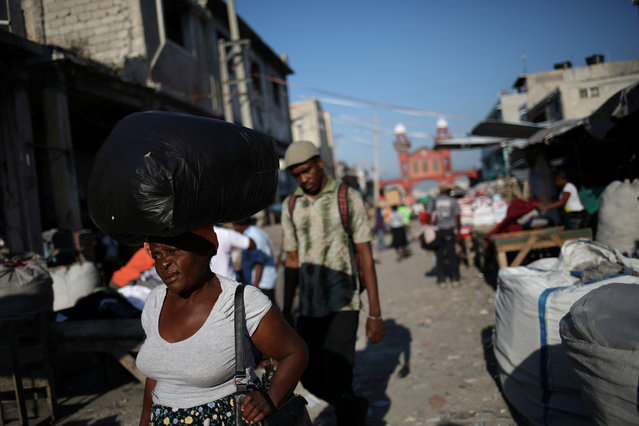 A woman carries goods on her head as she walks in a street in Port-au-Prince, March 8, 2018. (Photo by Andres Martinez Casares/Reuters)