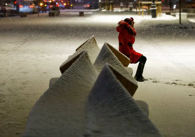 A woman sits on a bench as she poses for a picture during a snowfall in Almaty, Kazakhstan February 6, 2018. (Photo by Shamil Zhumatov/Reuters)