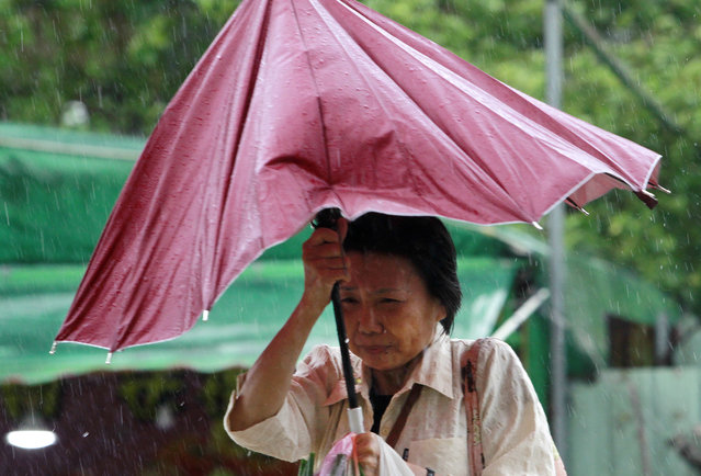 A woman struggles with her umbrella against powerful gusts of wind generated by typhoon Megi across the the island in Taipei, Taiwan, Tuesday, September 27, 2016. (Photo by Chiang Ying-ying/AP Photo)