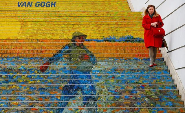 A woman walks down stairs advertising a Vincent van Gogh exhibition outside Albertina museum in Vienna, Austria, October 20, 2016. (Photo by Heinz-Peter Bader/Reuters)