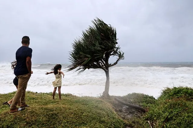 Members of the public look at strong waves in Saint-Benoit, on the east of the French Indian Ocean island of La Reunion, on February 2, 2022, ahead of the passage of tropical cyclone Batsirai. La Reunion goes on red alert at 7 pm on February 2, to prepare for the likely passage of cyclone Batsirai overnight. The cyclone already left at least 7,500 homes in nearby Mauritius without power, after it brought heavy downpours and winds of around 120 kilometres per hour, knocking down trees onto electricity lines, according to the local electricity board. (Photo by Richard Bouhet/AFP Photo)