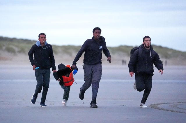 A young girl is run across the beach in Gravelines, France, where migrants are attempting to board a small boat to cross the Channel to the UK on Wednesday, October 22, 2025. (Photo by Gareth Fuller/PA Images via Getty Images)