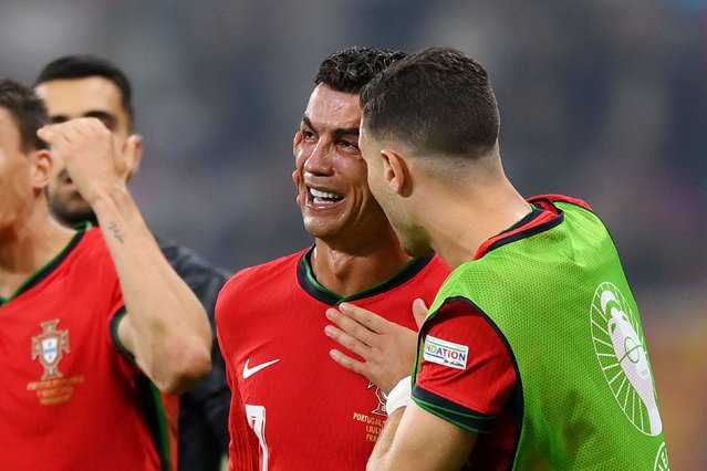 Portugal star Cristiano Ronaldo is consoled by a teammate during the Euro 2024 match against Slovenia on Monday, July 1, 2024. Ronaldo was upset that he had a penalty saved by Slovenian goalkeeper Jan Oblak in extra time, but Portugal went on to win anyway in a penalty shootout after the match ended scoreless. Ronaldo made amends by scoring one of the penalties in the shootout. (Photo by Justin Setterfield/Getty Images)