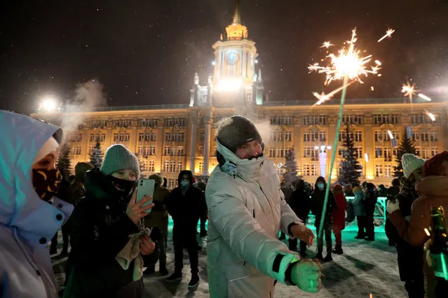 People attend New Year celebrations in 1905 Goda Square in Yekaterinburg, Russia on January 1, 2021. (Photo by Donat Sorokin/TASS)