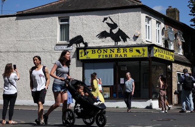 People view a newly confirmed Banksy artwork on the side of a fish and chip shop in Walthamstow in London, Britain, 09 August 2024. It is Banksy’s fifth confirmed animal artwork in the space of five days. (Photo by Andy Rain/EPA/EFE)