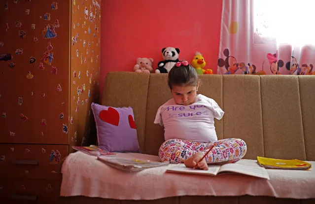 Ramela Meseljevic, a 7 year-old girl born without both of her hands and one of her legs shorter than the other, does her homework inside her house in Begov Han, Bosnia and Herzegovina December 2, 2015. International Day of Disabled Persons is observed on December 3 with the theme "Inclusion matters: access and empowerment of people of all abilities". (Photo by Dado Ruvic/Reuters)