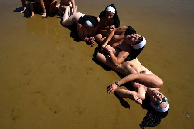 Participants dressed as nuns laugh on the beach after they joined 2505 women to break a Guinness World record for the largest number of people skinny dipping together and at the same time raising money for the children's cancer charity “Aoibheann's Pink Tie” on Magheramore beach near Wicklow, Ireland, June 9, 2018. (Photo by Clodagh Kilcoyne/Reuters)