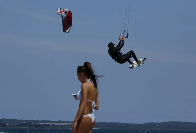 A kite surfer gets airborne past a beachgoer during warm Sydney weather, December 18, 2015. According to Australia's Bureau of Meterology the first heatwave for summer has hit large parts of Australia and is forecast to peak Saturday, with temperatures over 45 degrees Celsius (113 Fahrenheit) in some states. (Photo by Jason Reed/Reuters)