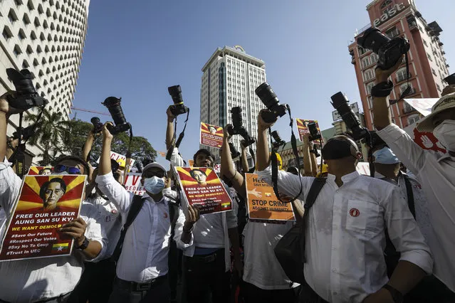 Photographers from the Myanmar Photographers Association hold up their cameras and placards calling for the release of detained Myanmar State Counselor Aung San Suu Kyi during a protest against the military coup in Yangon, Myanmar, 13 February 2021. People continued to rally across the country despite orders banning mass gatherings and reports of increasing use of force by police against anti-coup protesters. Myanmar's military seized power and declared a state of emergency for one year after arresting State Counselor Aung San Suu Kyi and Myanmar president Win Myint in an early morning raid on 01 February. (Photo by Nyein Chan Naing/EPA/EFE)