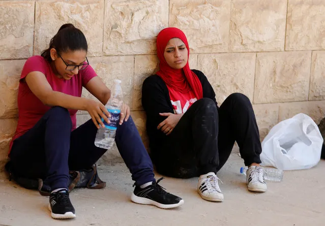 Egyptian women from Parkour Egypt “PKE” take a rest after playing around buildings on the outskirts of Cairo, Egypt on July 20, 2018. It is uncommon for women to play such sports on the streets in Egypt. A 2017 Thomson Reuters Foundation survey of experts on how women fared in mega cities rated Cairo as the world's most dangerous megacity for women, while London came out as best. (Photo by Amr Abdallah Dalsh/Reuters)