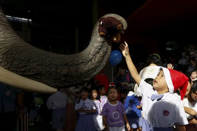 A child receives a puppet from an elephant as they attend a Christmas festival in a primary school in Ayutthaya, Thailand, December 24, 2015. (Photo by Jorge Silva/Reuters)