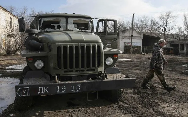 A member of a rebel unit of the self-proclaimed separatist Donetsk People's Republic walks past a truck damaged in clashes with the Ukrainian army in the village of Olenivka, south of Donetsk, February 7, 2015. (Photo by Maxim Shemetov/Reuters)