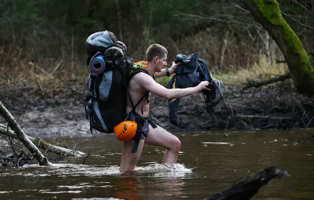 A Belarussian tourist crosses the river as he takes part in “Search and rescue operations – 2016”, a three-day competition, near the village of Priselki, Belarus, November 25, 2016. Photo taken November 25, 2016. (Photo by Vasily Fedosenko/Reuters)