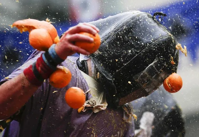 A member of a rival team is hit by an orange during an annual carnival battle in the northern Italian town of Ivrea February 15, 2015. (Photo by Max Rossi/Reuters)