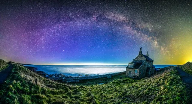 The Milky Way over Howick Bathing House at Howick near Alnwick in Northumberland, United Kingdom, captured at 4am on Sunday morning, March 19, 2023, just before dawn. The Northern Lights can be seen on the left of the image with the yellow on the right being light pollution. The panoramic photo was made using 12 photos merged together. (Photo by Ian Sproat/Picture Exclusive)
