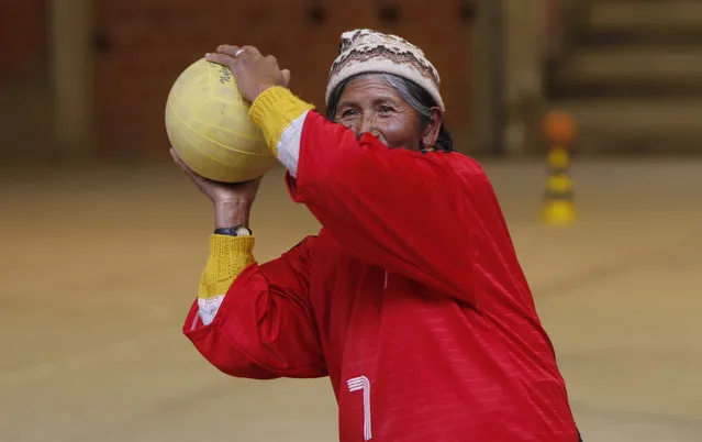 In this February 4, 2105 photo, 72-year-old Aurea Murillo prepares to make a pass during a handball match among elderly Aymara indigenous women in El Alto, Bolivia. Murillo said now that her children are grown she's dedicating time to herself and that playing handball makes her feel good. (Photo by Juan Karita/AP Photo)