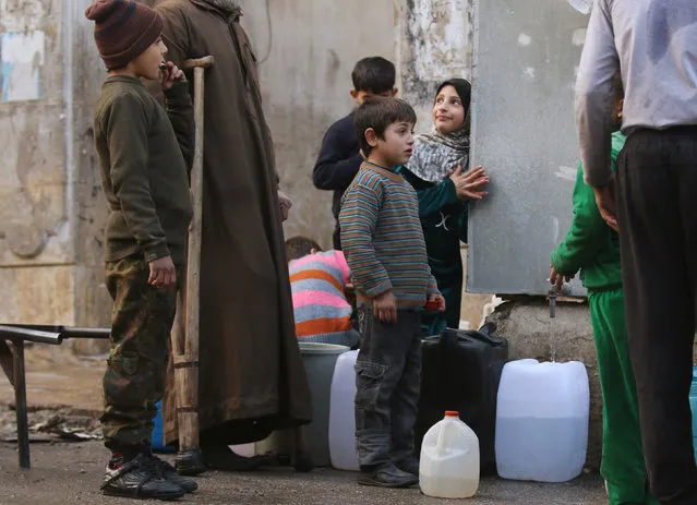 Children fill containers with water in a rebel-held besieged area of Aleppo, Syria December 10, 2016. (Photo by Abdalrhman Ismail/Reuters)