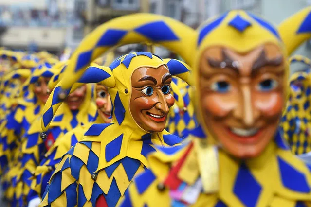 Costumed carnival revelers walk through the city during the “Narrensprung” (lit.fool's jump) parade in Lindau am Bodensee, Germany, 24 January 2016. Around 12,000 revelers populate the island of Lindau on Lake Constance. (Photo by Felix Kaestle/EPA)