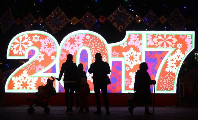 People are seen in front of big numbers reading 2017 at Oktyabrskaya Square for the upcoming New Year and Christmas season in Minsk, Belarus December 21, 2016. (Photo by Vasily Fedosenko/Reuters)
