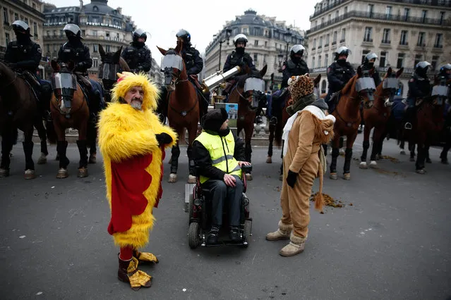 Protesters stand in front of mounted police during a demonstration in front of the Opera House in Paris against rising costs of living blamed on high taxes, on December 15, 2018. The “Yellow Vests” (Gilets Jaunes) movement in France originally started as a protest about planned fuel hikes but has morphed into a mass protest against President's policies and top-down style of governing. (Photo by Abdul Abeissa/AFP Photo)
